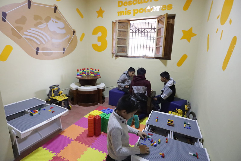 Niños jugando en mesas con legos